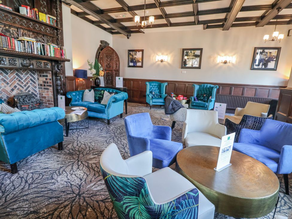 A lounge with armchairs and a coffee table at Woodlands Retreat in Llanfwrog near Ruthin