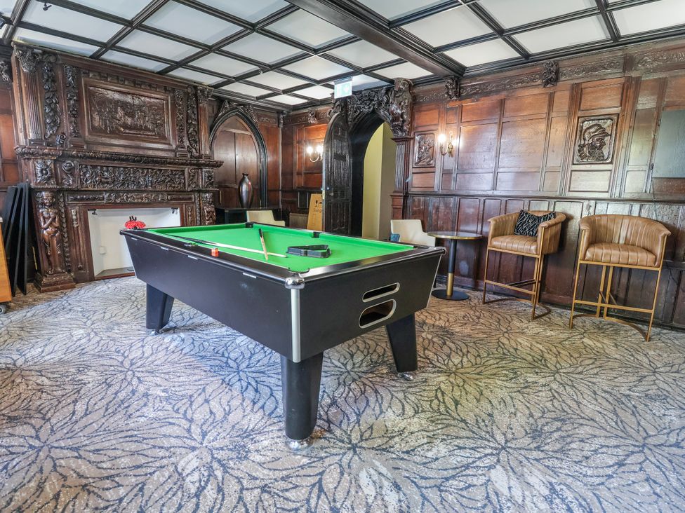 A game room with a pool table and bar stools at Woodlands Retreat Llanfwrog near Ruthin