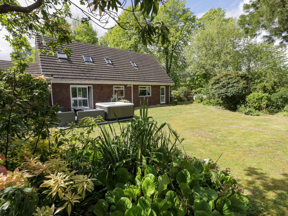A house with a hot tub and garden at Woodlands Retreat in Llanfwrog near Ruthin