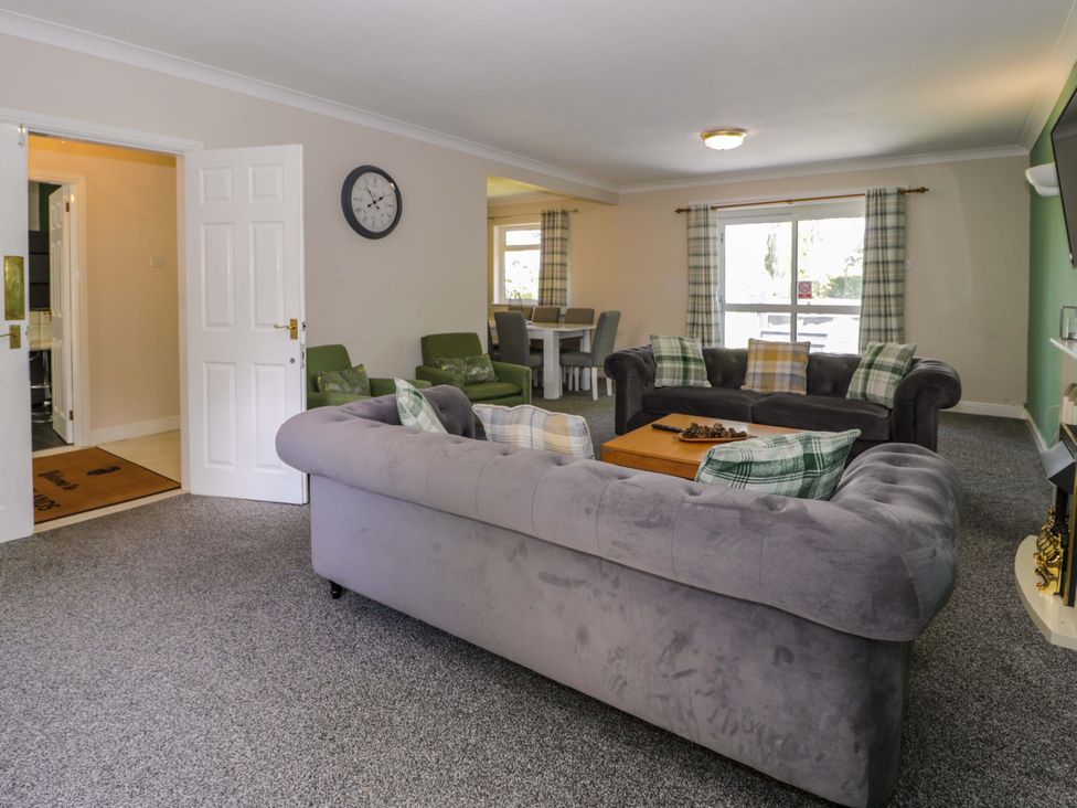 A living room with a sofa and table at Woodlands Retreat in Llanfwrog near Ruthin