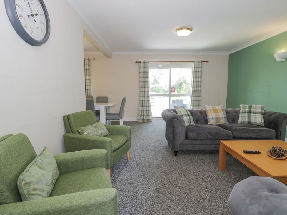 A living room with green and gray furniture at Woodlands Retreat in Llanfwrog near Ruthin