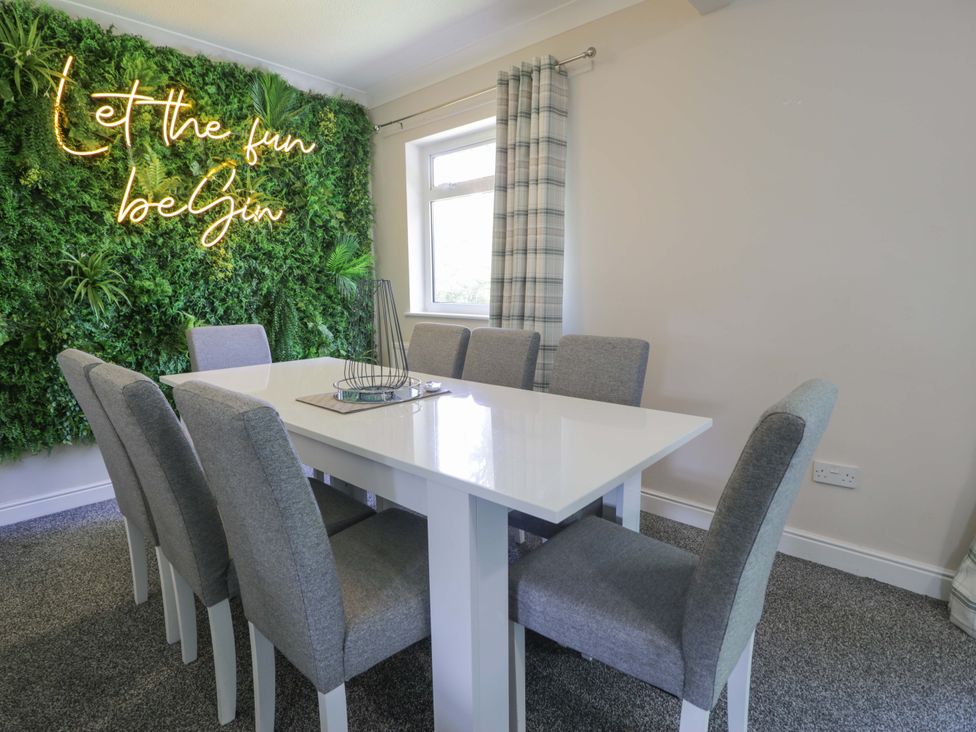 A dining room with a table and chairs at Woodlands Retreat in Llanfwrog near Ruthin