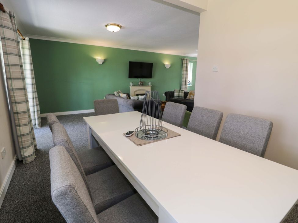 A dining room with a table and chairs at Woodlands Retreat in Llanfwrog near Ruthin