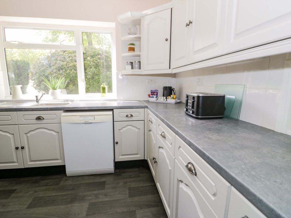 A kitchen with a dishwasher and toaster at Woodlands Retreat Llanfwrog near Ruthin