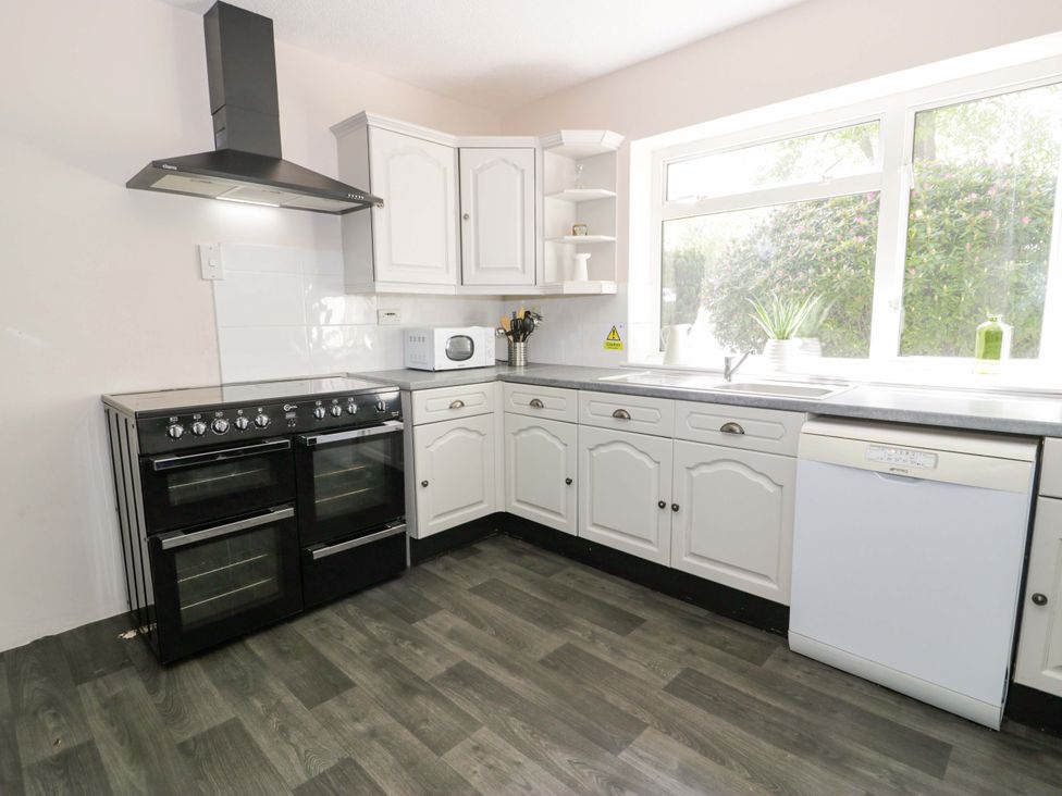 A kitchen with an oven, microwave, and dishwasher at Woodlands Retreat in Llanfwrog near Ruthin
