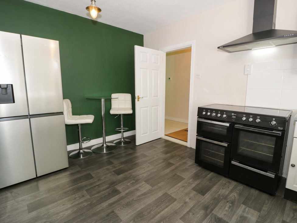 A kitchen with a refrigerator and an oven at Woodlands Retreat Llanfwrog near Ruthin