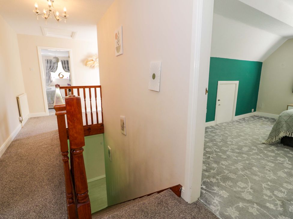 A hallway with a staircase leading to a room at Woodlands Retreat in Llanfwrog near Ruthin