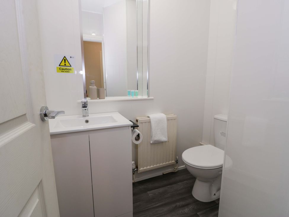 A bathroom with a sink and toilet at Woodlands Retreat in Llanfwrog near Ruthin