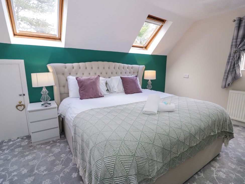 A bedroom with a bed and nightstand at Woodlands Retreat Llanfwrog near Ruthin