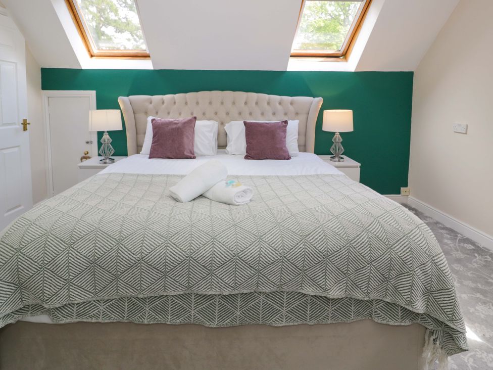 A bedroom with a bed and bedside lamps at Woodlands Retreat Llanfwrog near Ruthin