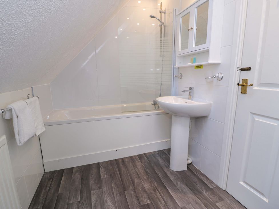 A bathroom with a bathtub and sink at Woodlands Retreat Llanfwrog near Ruthin