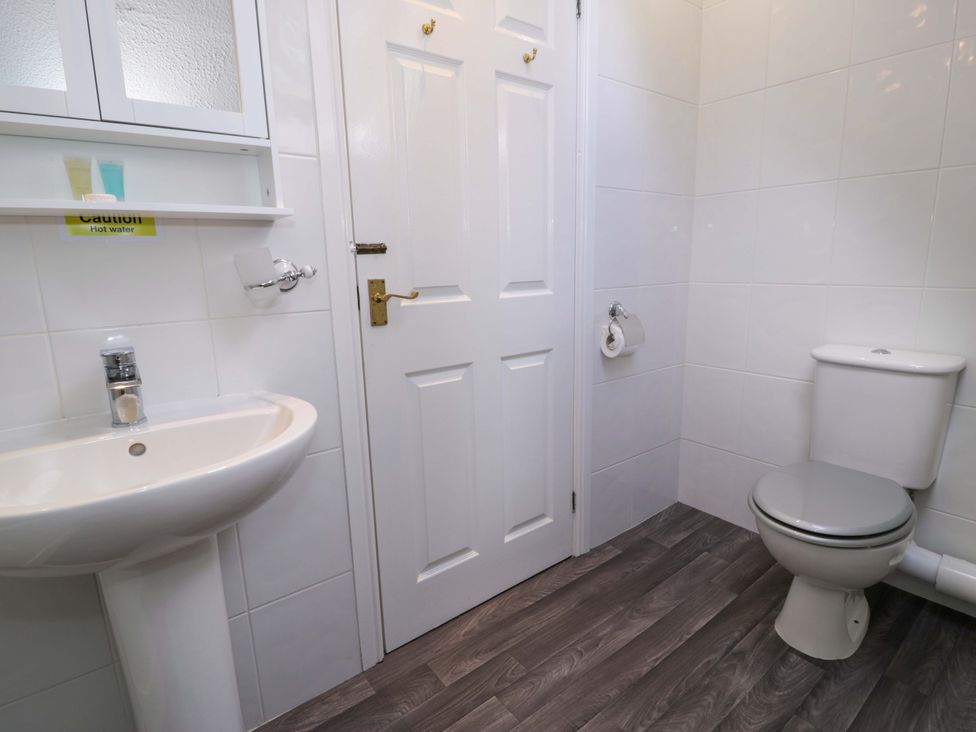 A bathroom with a sink and toilet at Woodlands Retreat in Llanfwrog near Ruthin