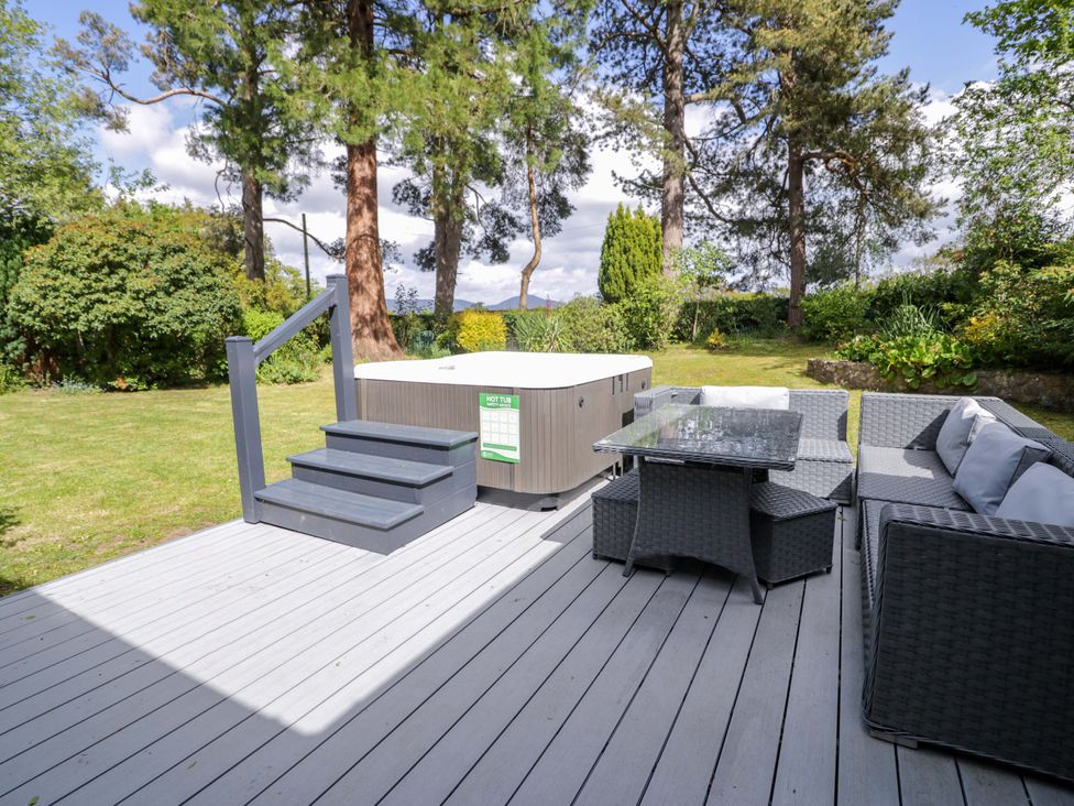A garden with a hot tub and seating area at Woodlands Retreat in Llanfwrog near Ruthin