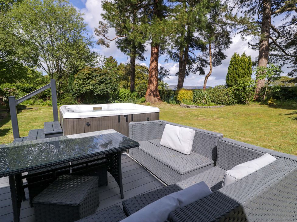 An outdoor seating area with a hot tub at Woodlands Retreat in Llanfwrog near Ruthin