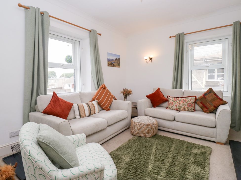 A living room with sofas and a rug at 3 Nixon Terrace Broughton Moor near Maryport