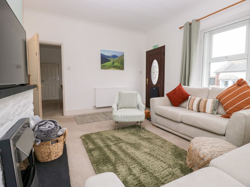 A living room with a sofa and armchair at 3 Nixon Terrace Broughton Moor near Maryport