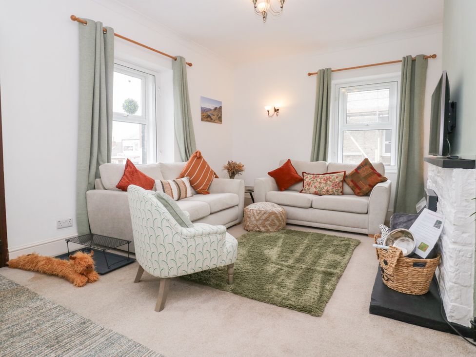 A living room with sofas and an armchair at 3 Nixon Terrace Broughton Moor near Maryport