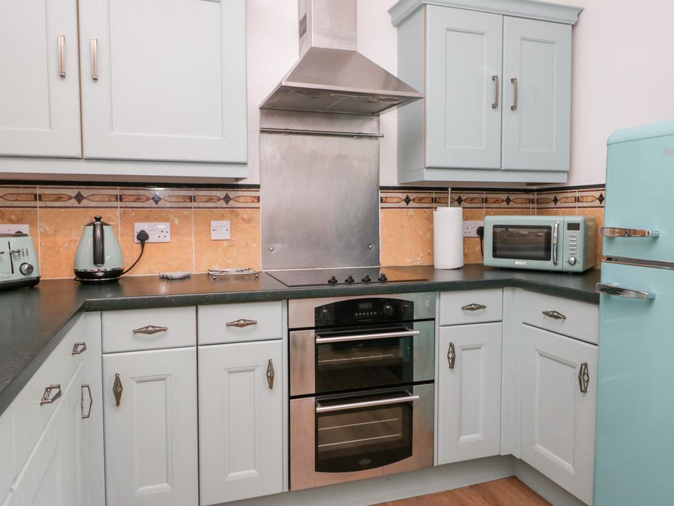 A kitchen with appliances and cabinets at 3 Nixon Terrace, Broughton Moor near Maryport