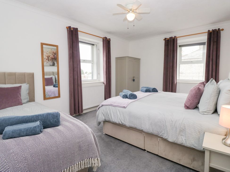 A bedroom with two beds and a wardrobe at 3 Nixon Terrace, Broughton Moor near Maryport
