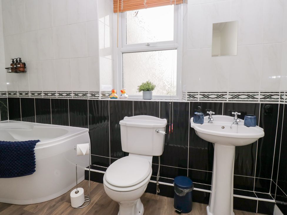 A bathroom with a bathtub toilet and sink at 3 Nixon Terrace Broughton Moor near Maryport
