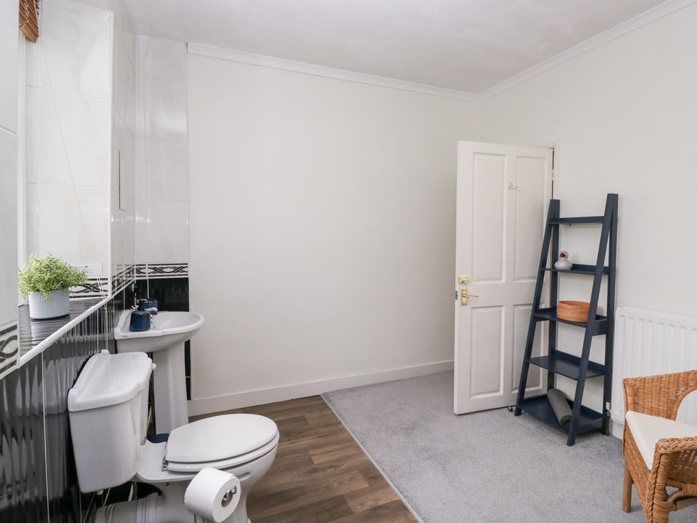 A bathroom with toilet, sink, and shelf at 3 Nixon Terrace Broughton Moor near Maryport