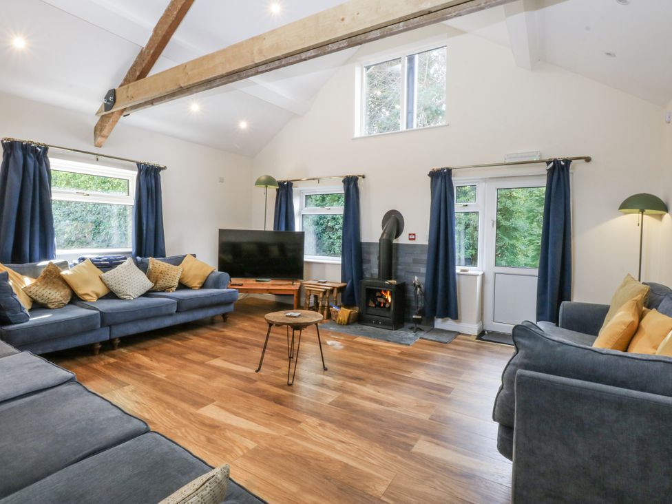 A living room with a television and a wood stove at Tawelfan in Llwyngwril