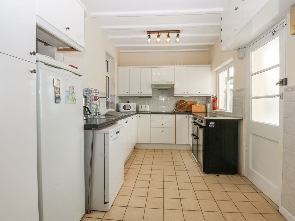A kitchen with appliances and cabinets at Tawelfan in Llwyngwril
