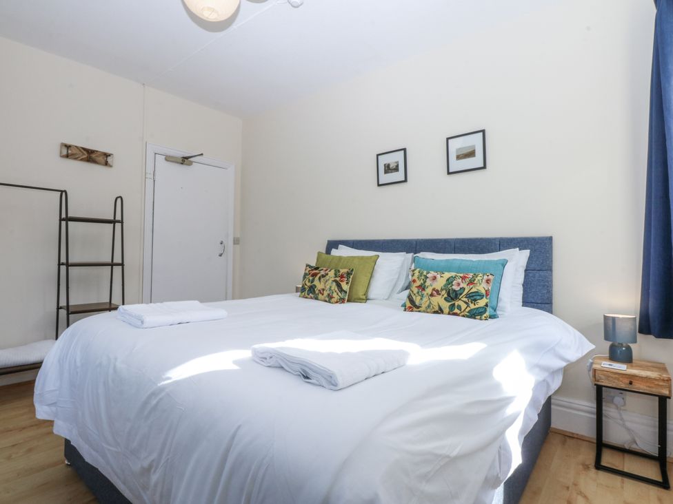 A bedroom with a double bed and bedside table at Tawelfan in Llwyngwril