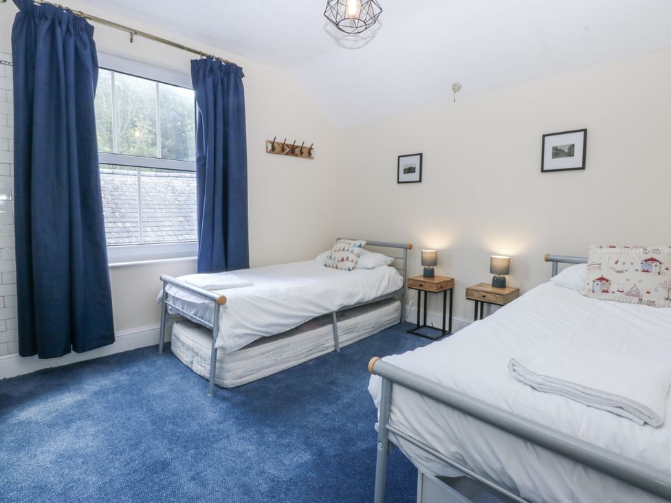 A bedroom with two beds and nightstands at Tawelfan Llwyngwril