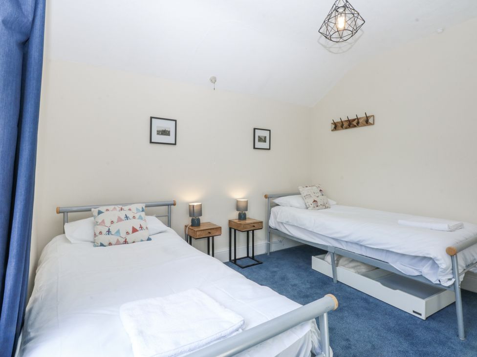 A bedroom with two beds and nightstands at Tawelfan in Llwyngwril