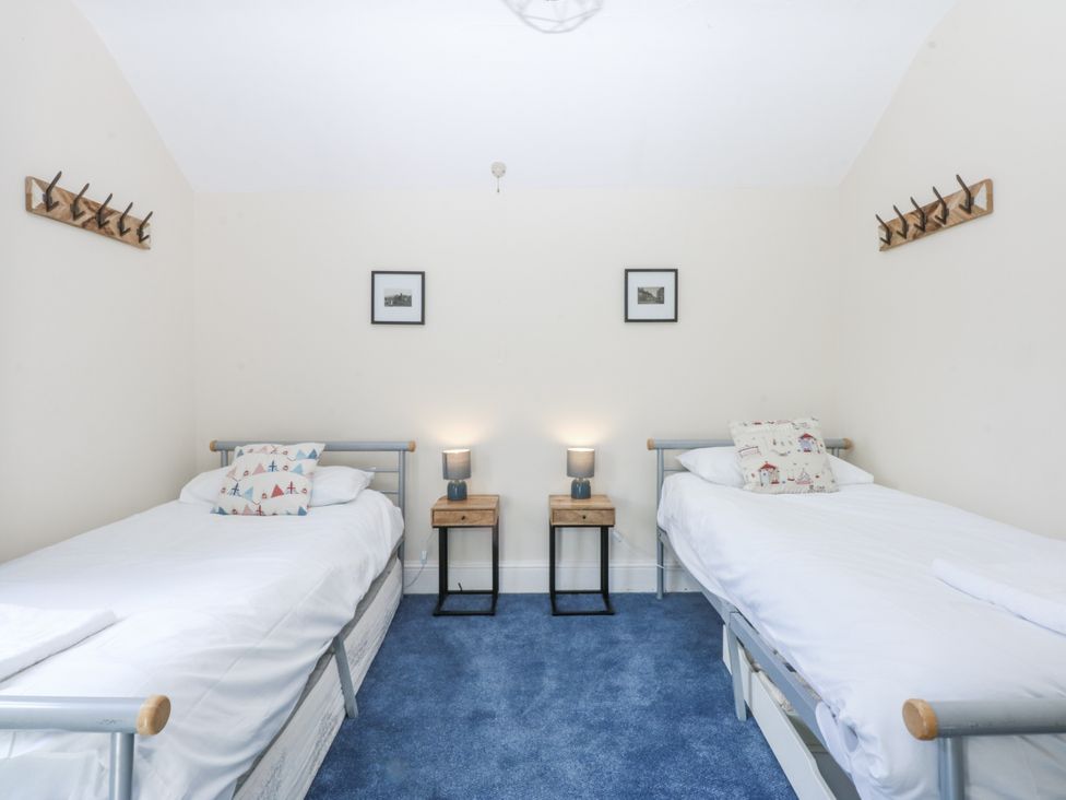 A bedroom with two beds and nightstands at Tawelfan in Llwyngwril