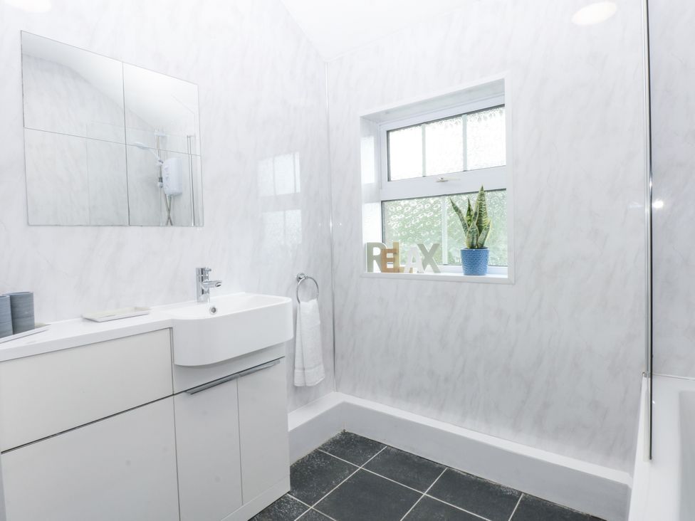 A bathroom with a sink and shower at Tawelfan in Llwyngwril