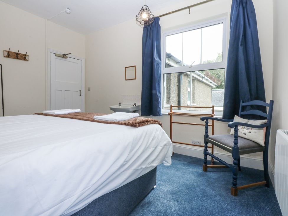 A bedroom with a bed and chair at Tawelfan in Llwyngwril