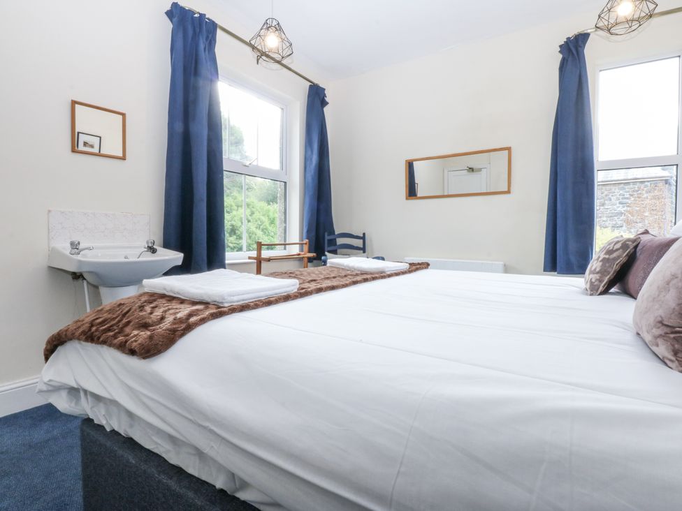 A bedroom with a bed and sink at Tawelfan in Llwyngwril