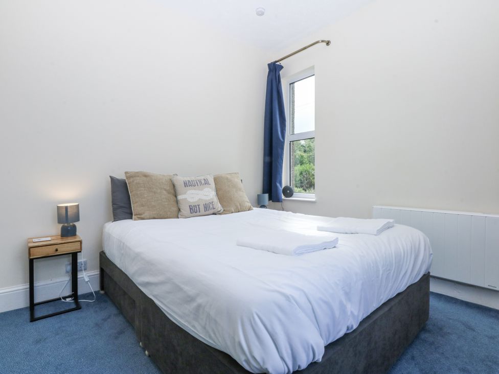 A bedroom with a bed and bedside table at Tawelfan in Llwyngwril