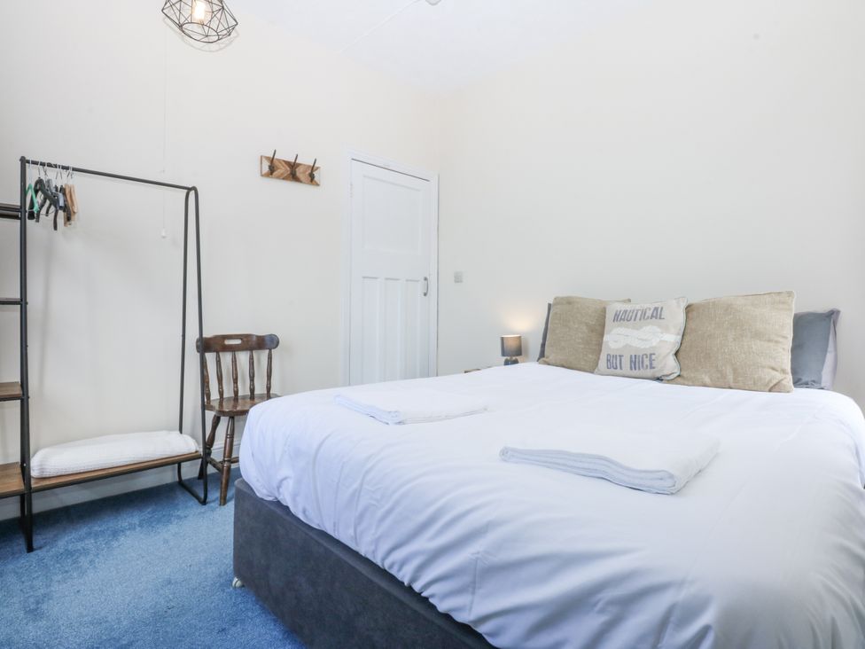 A bedroom with a bed and a chair at Tawelfan in Llwyngwril
