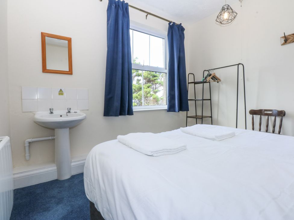 A bedroom with a bed and a sink at Tawelfan in Llwyngwril