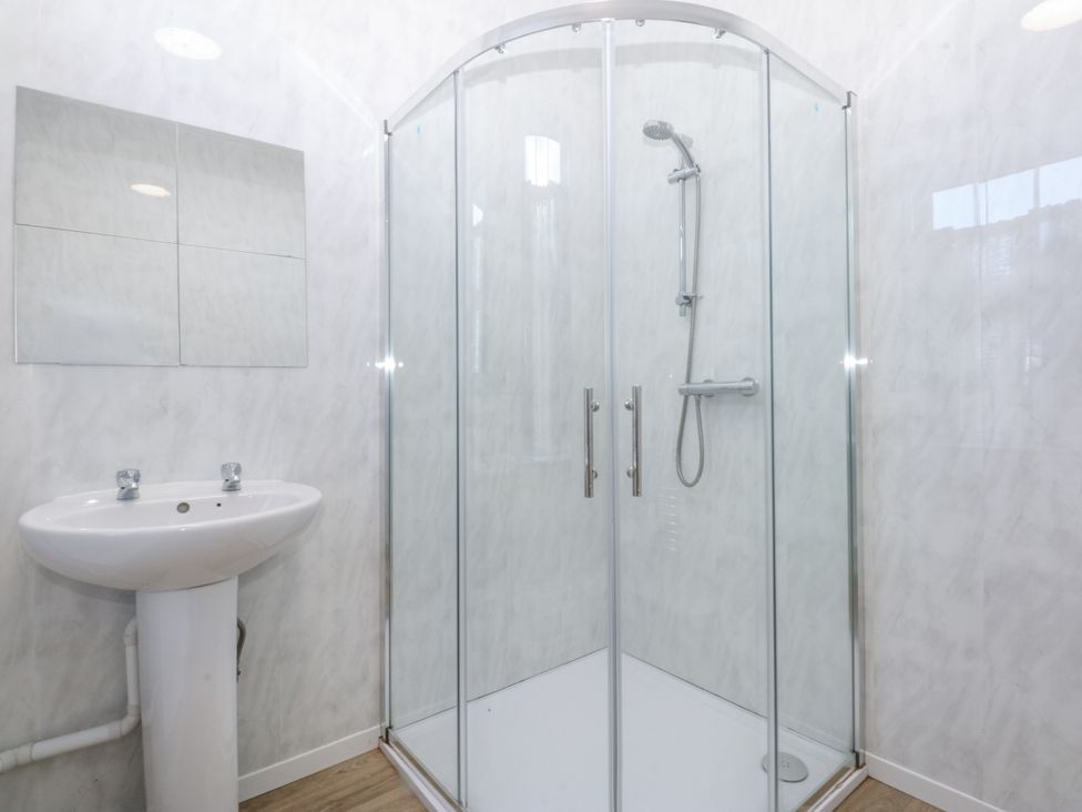 A shower and sink in a bathroom at Tawelfan in Llwyngwril