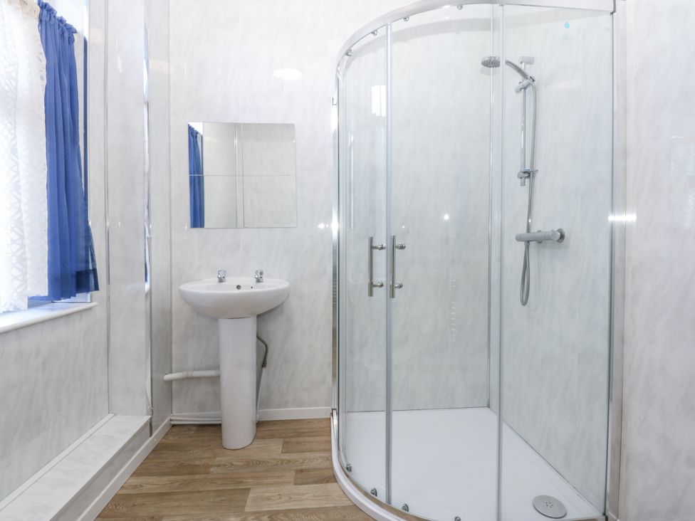 A bathroom with a shower and sink at Tawelfan in Llwyngwril