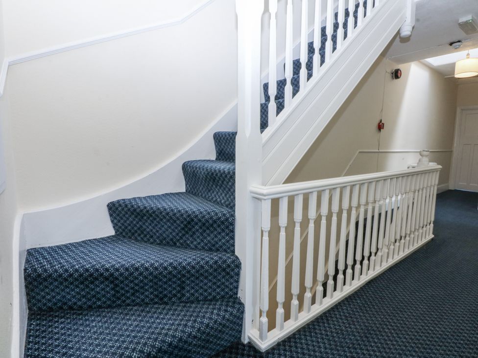 A staircase with carpet and handrail at Tawelfan in Llwyngwril