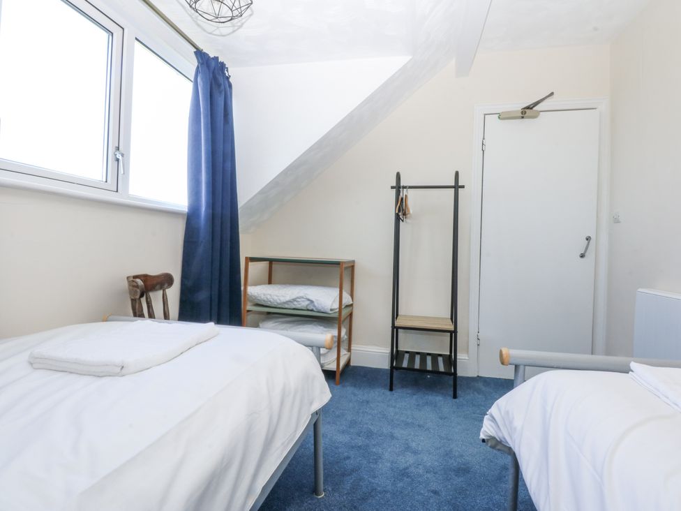 A bedroom with two beds and a hanging rack at Tawelfan in Llwyngwril