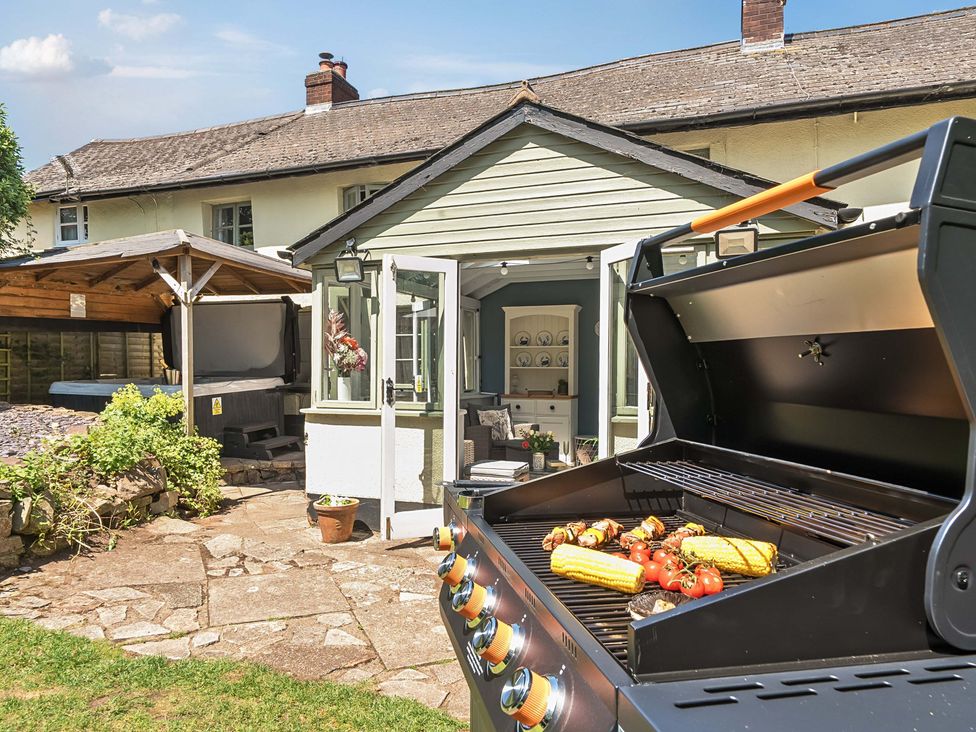 An outdoor area with a grill and vegetables at 2 Pigsfoot Cottages in Ash Thomas near Halberton, Devon