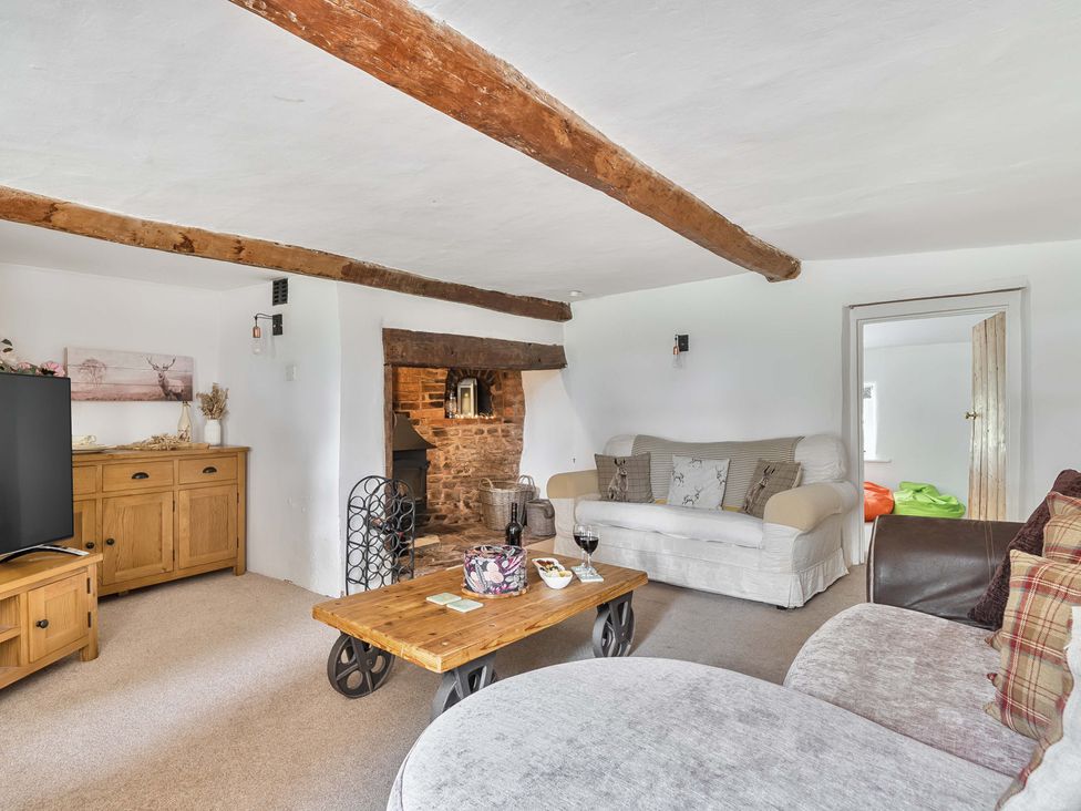 A living room with a sofa and a TV at 2 Pigsfoot Cottages Ash Thomas near Halberton, Devon