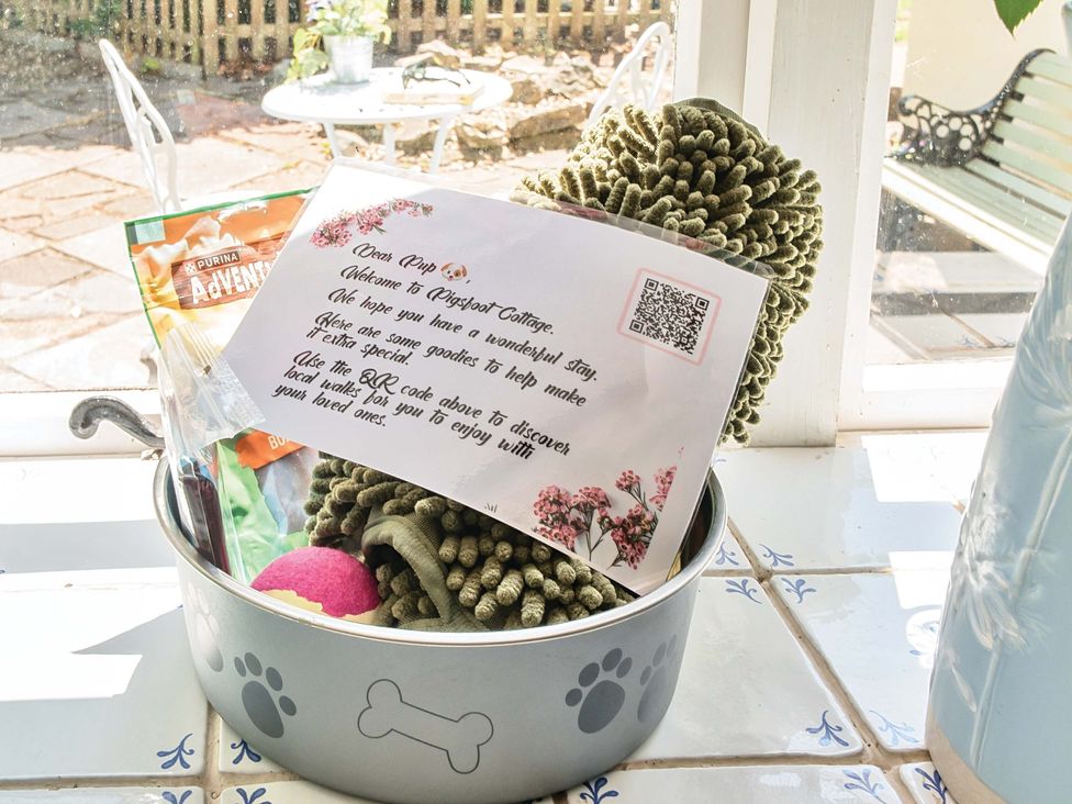 A dog bowl with toys and treats along with a welcome note at 2 Pigsfoot Cottages Ash Thomas near Halberton, Devon