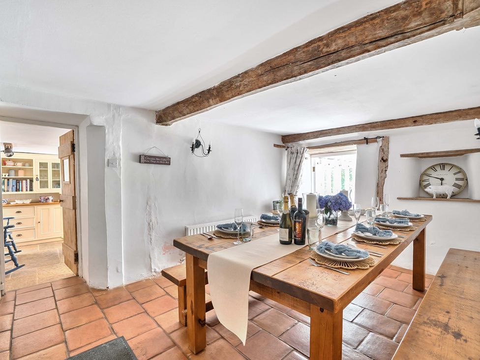 A dining room with a wooden table set for a meal at 2 Pigsfoot Cottages Ash Thomas near Halberton, Devon