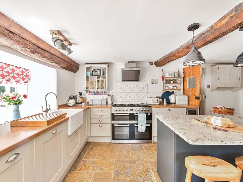 A kitchen with cabinets and stove at 2 Pigsfoot Cottages Ash Thomas near Halberton, Devon