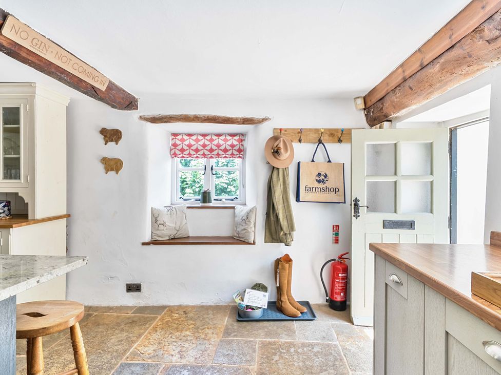 A kitchen with a seat by the window at 2 Pigsfoot Cottages Ash Thomas near Halberton, Devon