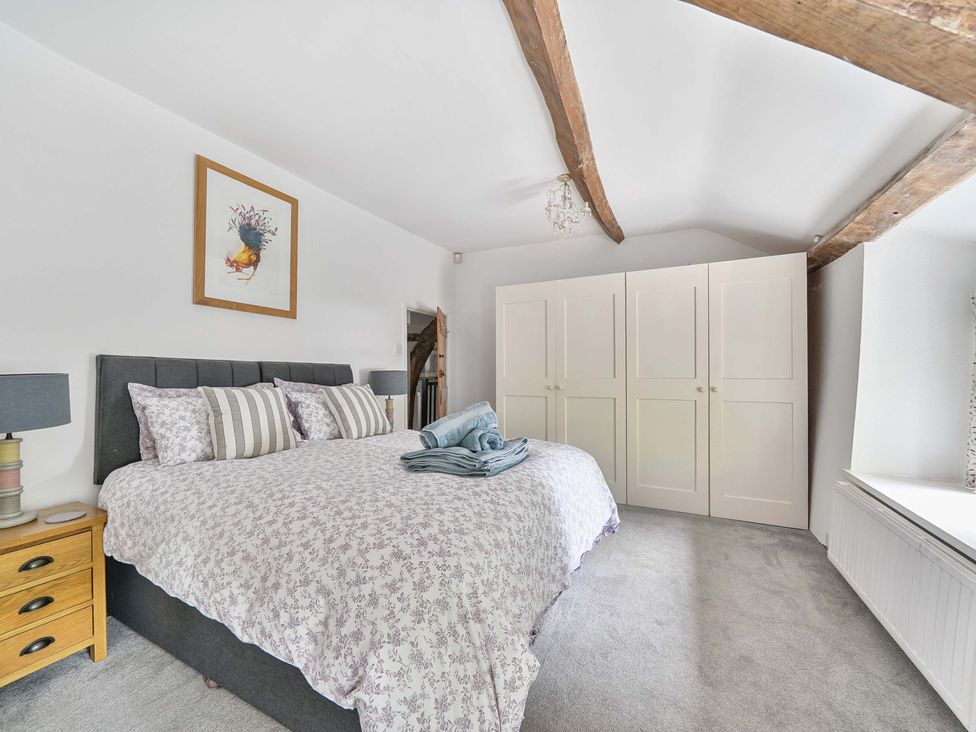 A bedroom with a bed and wardrobe at 2 Pigsfoot Cottages Ash Thomas near Halberton, Devon