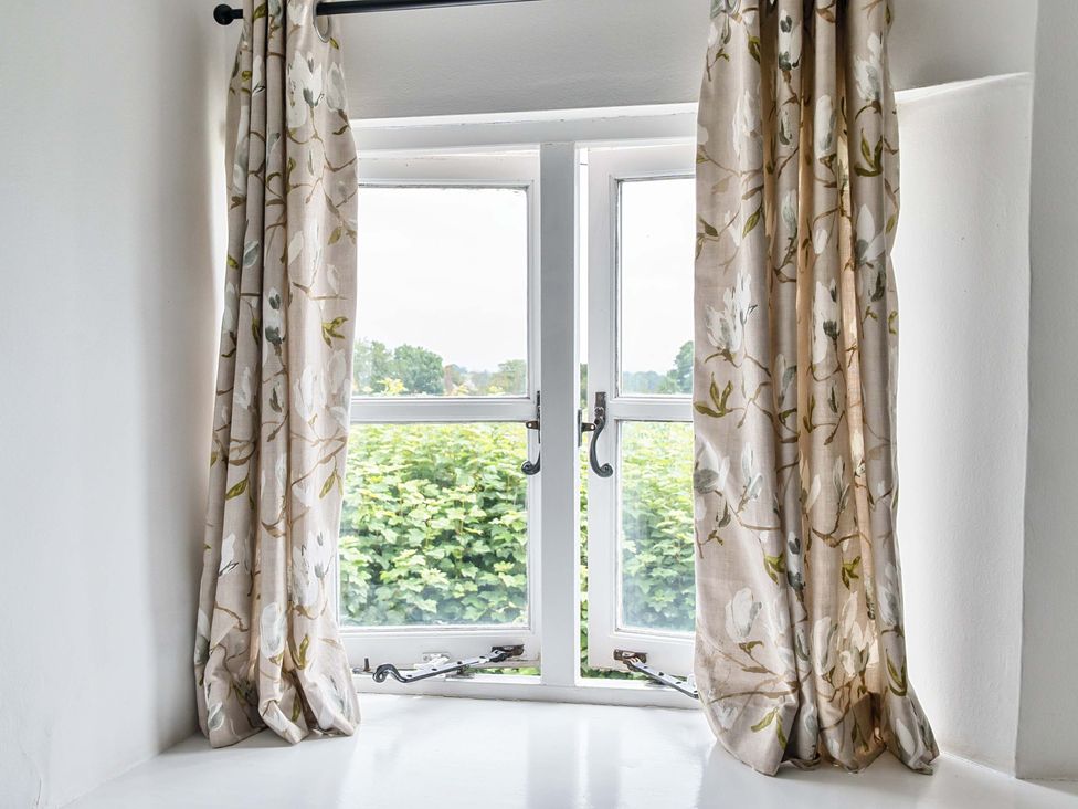 A window with curtains in a living room at 2 Pigsfoot Cottages Ash Thomas near Halberton, Devon