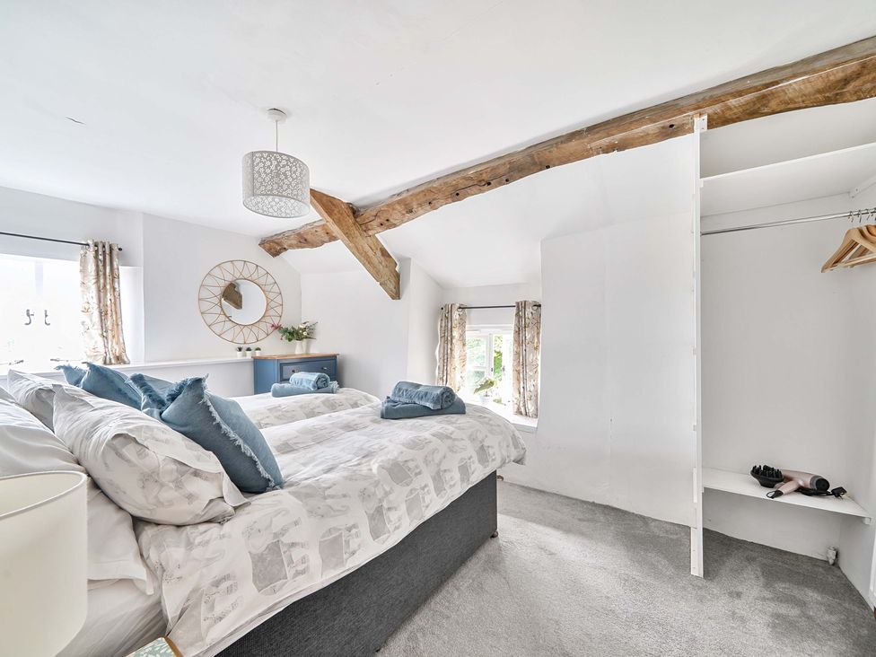 A bedroom with a bed and shelf at 2 Pigsfoot Cottages in Ash Thomas near Halberton, Devon